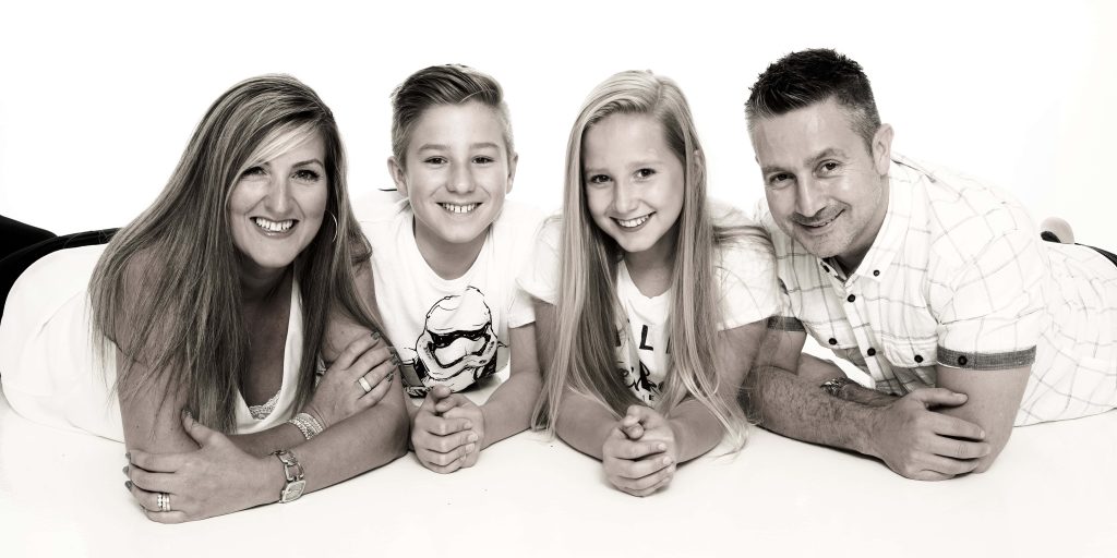 Candid sibling moment during indoor family photoshoot at Leicester photography studio